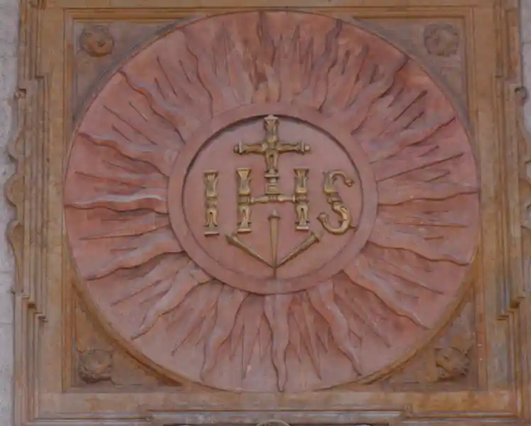 Cross with Jesus monogram IHS inside a solar disc